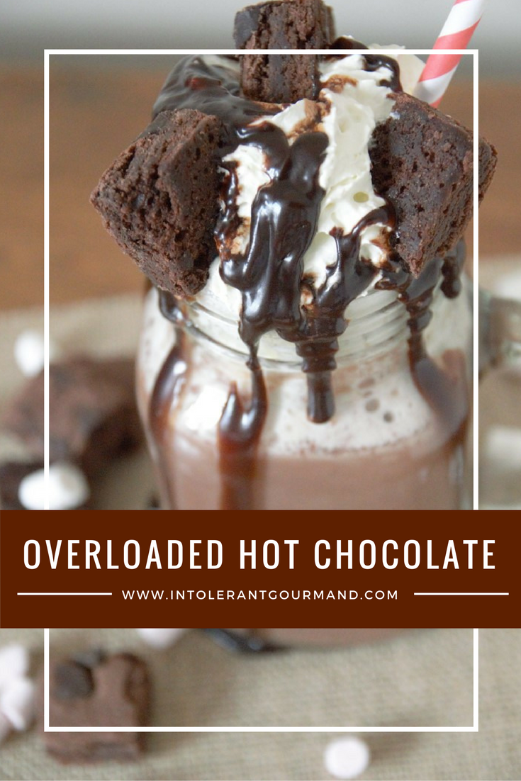 Overloaded hot chocolate- decadent hot chocolate, with a subtle hint of cinnamon and nutmeg, and orange. Topped with whipped cream, chocolate sauce, brownie bites and mini marshmallows. www.intolerantgourmand.com